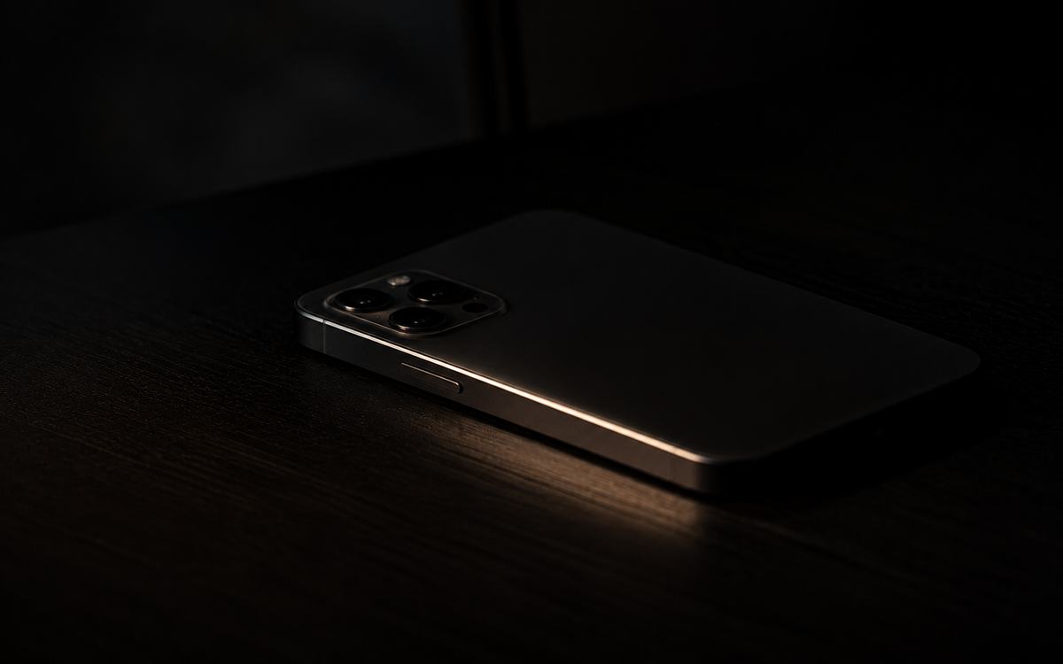 A phone left face-down on a dark desk, representing the late-night confusion of researching crypto alone